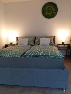 a bed in a bedroom with two lamps on the wall at Vinea Apartma in Gornja Radgona +32 photos
