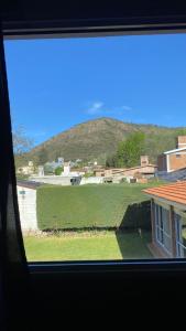 a view of a field from a window of a house at Casa de vacaciones Naty in Villa Carlos Paz