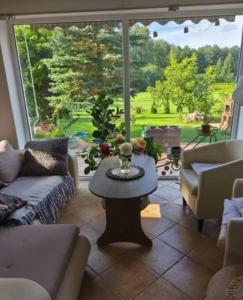 a living room with a table and a large window at Willa Myśliwska Giżycko in Giżycko +15 photos