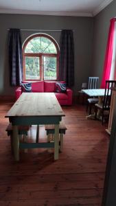 a living room with a red couch and a table at Hostel Villa Nova in Mossel Bay