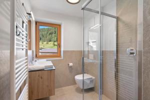 a bathroom with a toilet and a glass shower at Residence Froy in Resia +206 photos