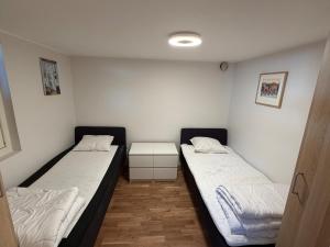 two beds in a room with white walls at Lägenhet 36B in Båstad