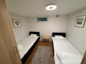 two beds in a small room with white sheets at Lägenhet 36B in Båstad +4 photos
