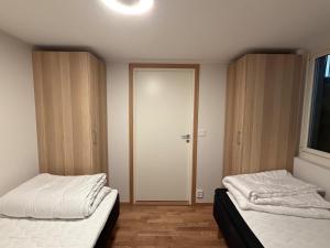 two beds sitting in a room with a door at Lägenhet 36B in Båstad