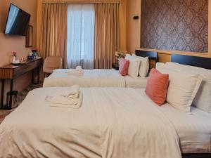 two beds in a hotel room with towels on them at Guest house TWINS in Tashkent +56 photos