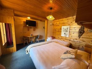 a bedroom with a bed and a table in it at Hôtel Restaurant La Pendine in Puy-Saint-Vincent