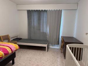 a bedroom with a bed and a desk and a window at Private Room in Shared Apartment in Vaasa