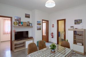 a living room with a table and chairs and a television at Apartamento La Molina in Rute