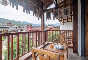 a balcony with a table and a view of a village at Zhangjiajie Yun Hai Hotel- Ancient Chinese Style Hotel,Tea Culture Experience, Realxing Class,Free Breakfast ,Local Travel Guide and Book Tickets, Gem Perporty in Zhangjiajie