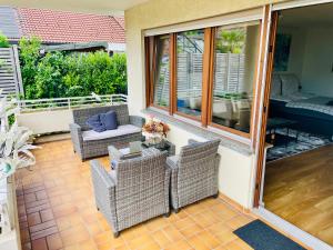 a patio with wicker chairs and a table at Relax Holidays in Rheinheim
