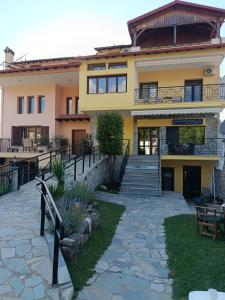 a large yellow house with stairs and a patio at SmallHotel - Vevi in Vévi