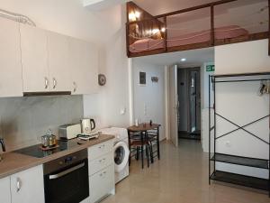 a kitchen with white cabinets and a washer and dryer at The Eliana Serenade in Heraklio