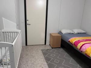a bedroom with a bed and a dresser and a crib at Private Room in Shared Apartment in Vaasa