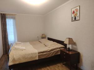 a bedroom with a bed and a table with a lamp at Relax in the mountains - kazbegi in Arsha