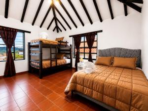 a bedroom with a bed and two bunk beds at hotel spa 360 villa de leyva in Villa de Leyva