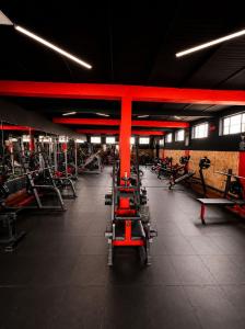 a gym with rows of exercise equipment and red beams at hotel spa 360 villa de leyva in Villa de Leyva