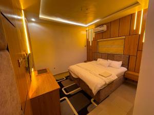 a small room with a bed and a desk at MOTISOFT Hotel in Yenagoa