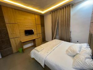 a bedroom with a bed and a tv on a wall at MOTISOFT Hotel in Yenagoa