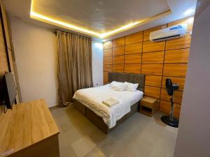 a bedroom with a bed with a wooden wall at MOTISOFT Hotel in Yenagoa