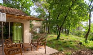 a patio with two wooden chairs and a house at Maison confortable à Velleron de 50 m² avec piscine in Velleron