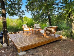 two chairs and a table on a wooden deck at Maison confortable à Velleron de 50 m² avec piscine in Velleron
