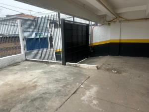 an open gate in a building with a fence at Hotel New City in Guarulhos
