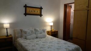 a bedroom with a bed with pillows and two lamps at Los Mochos Portezuelo in Punta del Este