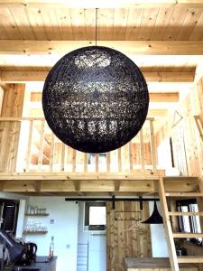 a black chandelier hanging from the ceiling of a room at Tiny House of Happiness - shared hot tub in Otterlo