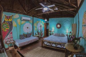 a bedroom with a bed and a painting on the wall at Hostal Rosa Mística in Montañita