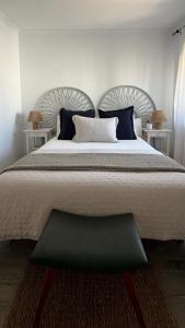 a bedroom with a large bed with blue pillows at Apartamento Rural en Valencia de Alcántara in San Pedro +4 photos