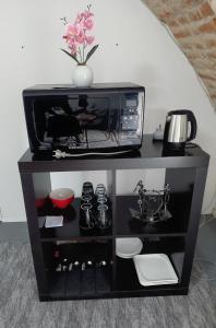a black cabinet with a microwave and a vase on top at Ubytovanie Čadca in Čadca