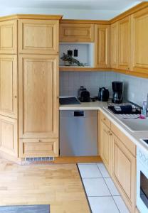 a kitchen with wooden cabinets and white appliances at Ferienwohnung Gartenblick in Amerang