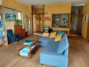 a living room with a blue couch and a table at B&B Tramonti sull'Adriatico in Muggia