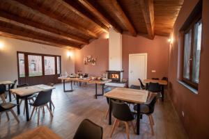 a dining room with tables and chairs and a fireplace at CASALE DILETTOSO Etna Relais in Randazzo