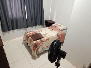a small bed in a room with a camera at Pedacinho do céu 3 in Dourados