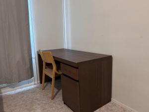 a wooden desk with a chair next to a wall at Private Room in Shared Apartment in Vaasa
