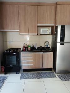 a kitchen with a refrigerator and a stove at Pedacinho do céu 3 in Dourados