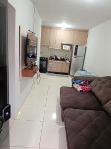 a living room with a couch and a kitchen at Pedacinho do céu 3 in Dourados