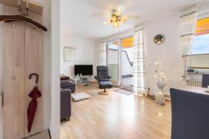 a living room with a couch and a chair and a television at Traumwohnung am Sorpesee in Sundern