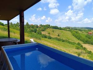 ein blauer Swimmingpool mit Blick auf einen Hügel in der Unterkunft Sweet Dalia in Molvice
