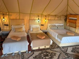 a room with three beds in a tent at Camels house apartment in Adrouine
