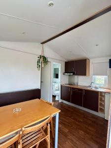 a kitchen and dining room with a wooden table at Parque De Campismo Orbitur Sao Pedro De Moel in São Pedro de Moel