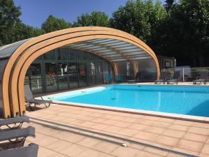 a swimming pool with an arch over it at La Villa du Pont Romain in Saint-Nectaire
