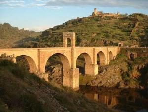 a bridge with arches on a hill next to a mountain at Apartamento Rural en Valencia de Alcántara in San Pedro