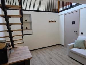 a living room with a staircase and a couch at L oasis de Détente - le Cocon - gîte 4 personnes avec 1h d accès à la piscine privée et terrasse aménagée par nuit réservée - climatisation - à 2km de Pairi Daiza in Brugelette