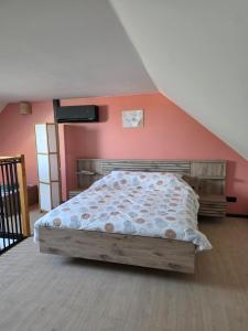 a bedroom with a bed and a red wall at L oasis de Détente - le Cocon - gîte 4 personnes avec 1h d accès à la piscine privée et terrasse aménagée par nuit réservée - climatisation - à 2km de Pairi Daiza in Brugelette