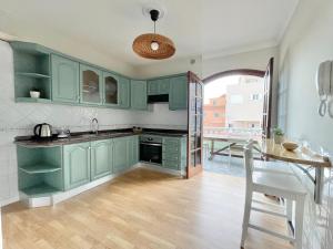 a kitchen with green cabinets and a table and a dining room at La Casa de Papel 2 in Valle Gran Rey
