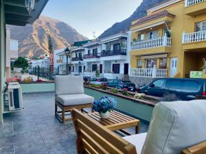 a balcony with a bench and a chair and some buildings at La Casa de Papel 2 in Valle Gran Rey