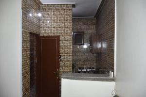 a bathroom with a brown door and a brick wall at Nobal best house in Aswan
