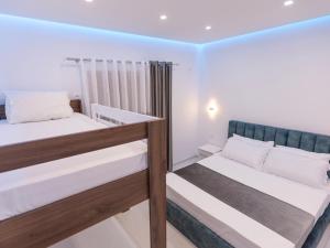 two bunk beds in a room with white walls at Sunrise Hotel Vila in Vlorë